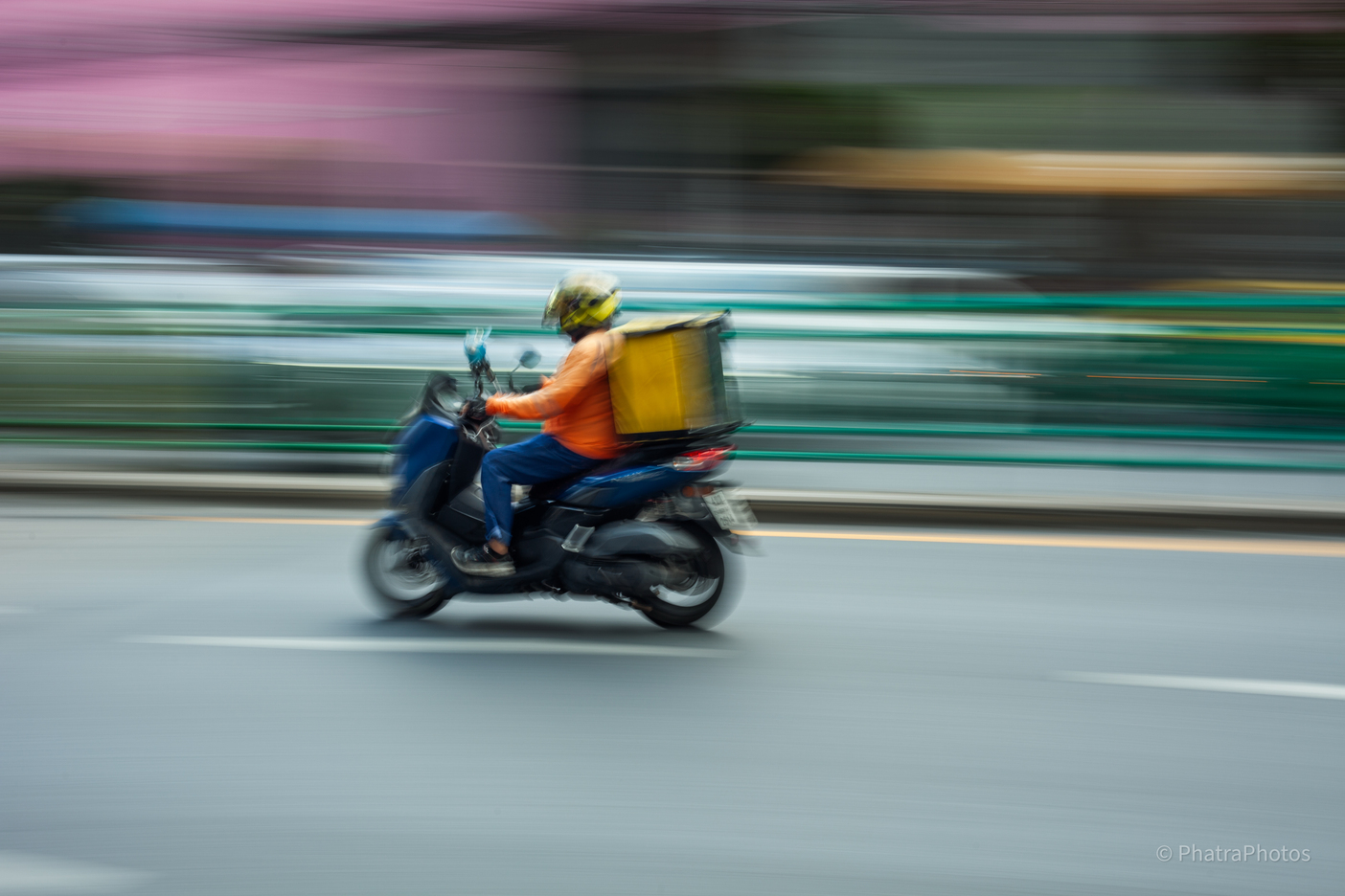 Delivery rider on a scooter, panning blur
