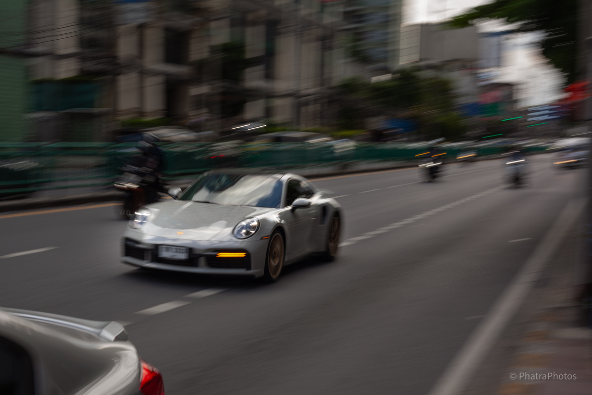 Silver sports car passing, panning shot